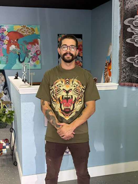 Dennis Corzo, owner and tattoo artist at Blind Fox Tattoo in Amarillo, TX, standing in the studio