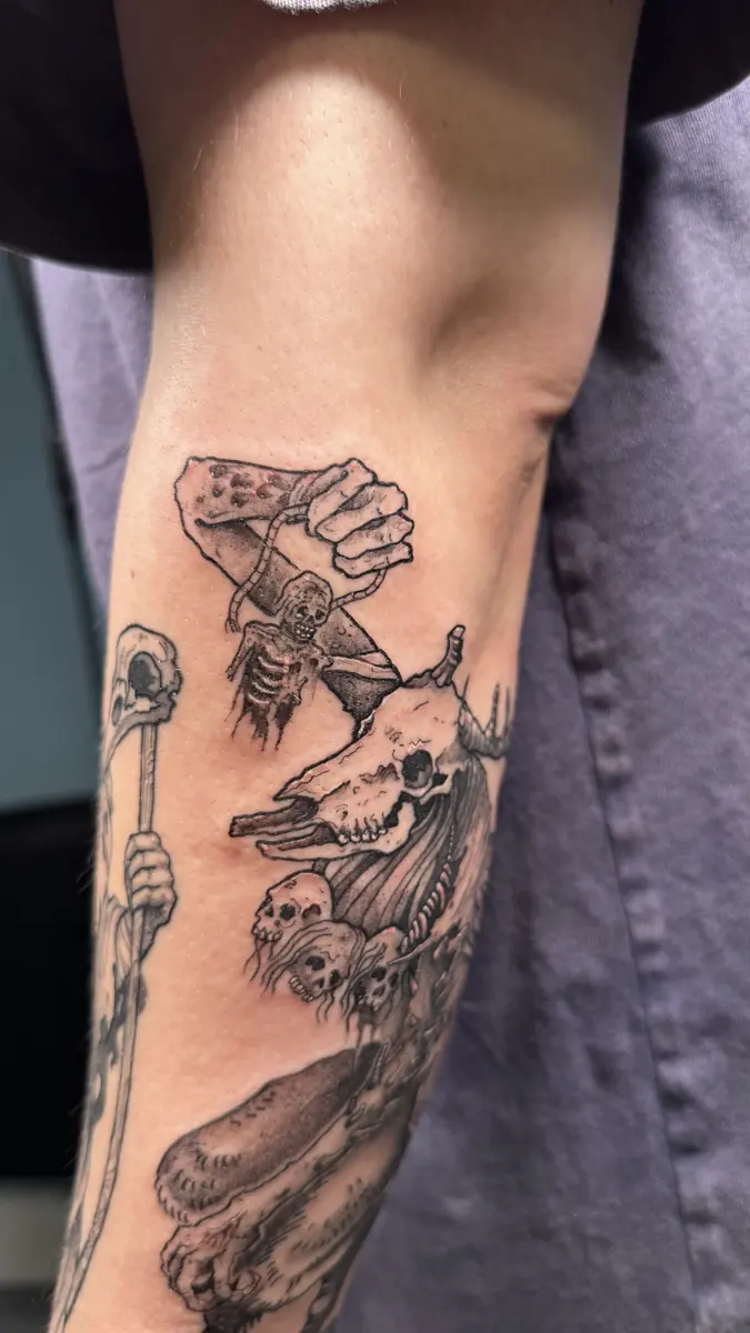 Blackwork forearm tattoo of a skeletal hand holding a lit candle