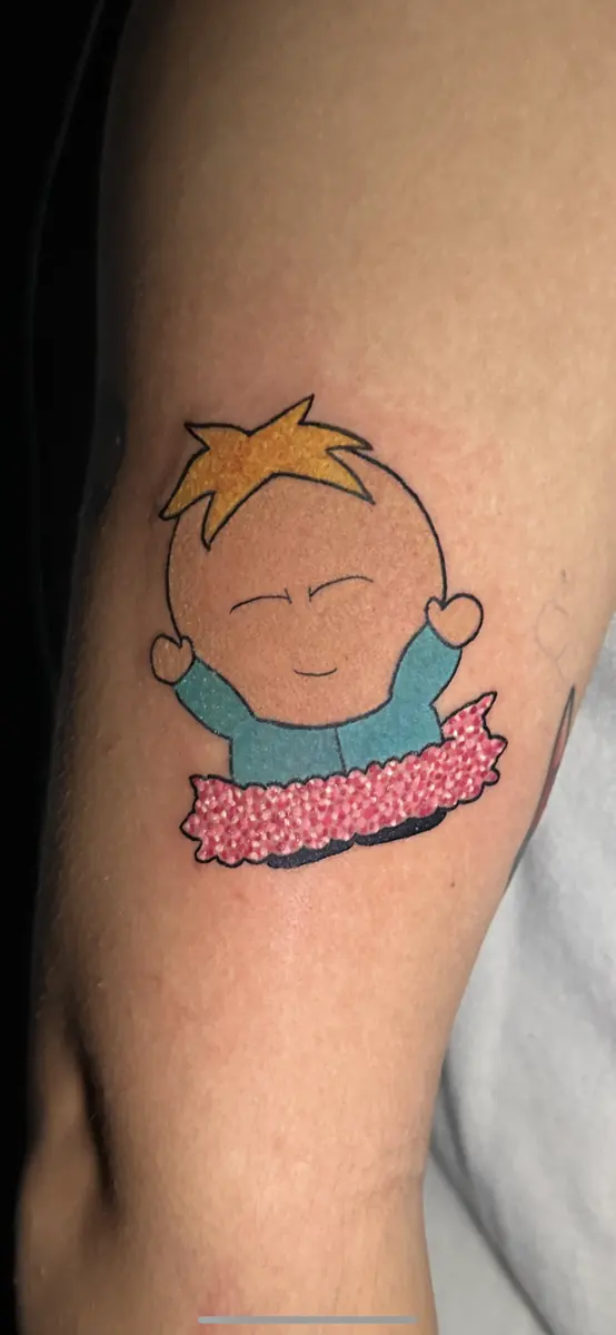 Colour cartoon character tattoo with a pink glitter blanket on an upper arm