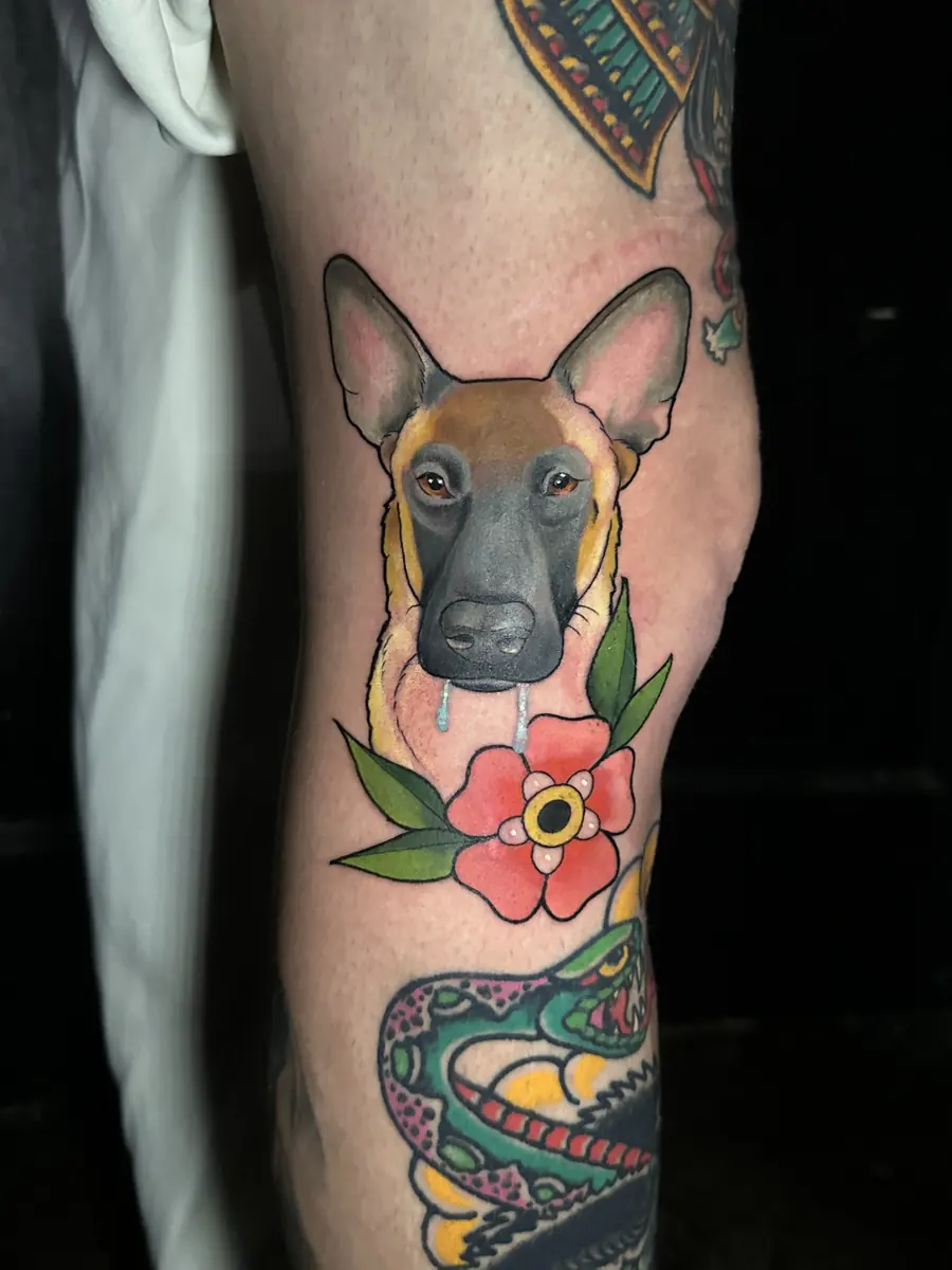 Neo-traditional dog portrait tattoo with a red flower, part of a color leg sleeve, tattooed at Blind Fox Tattoo in Amarillo, TX