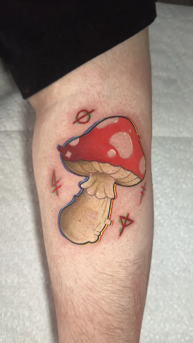 Neo-traditional red toadstool mushroom tattoo on a thigh
