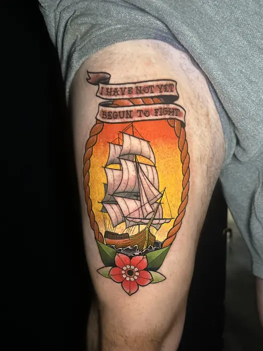 Traditional tattoo of a tall ship inside a bottle with a lettered banner above it